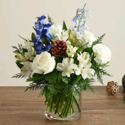 White and blue floral arrangement in a clear glass vase
