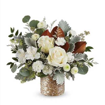 White roses and small white flowers in a woven basket vase