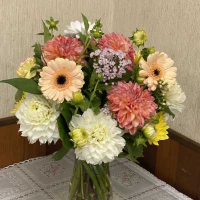 Mixed bouquet of dahlias and gerbera daisies in a glass vase