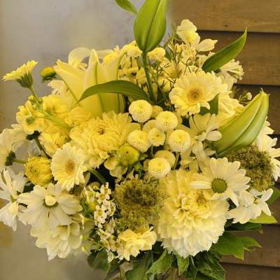 Yellow and white mixed flower arrangement in a glass vase