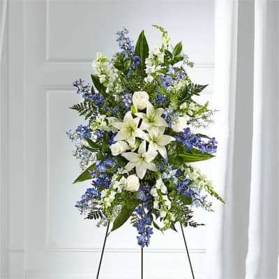 Tall white and blue floral standing spray on an easel