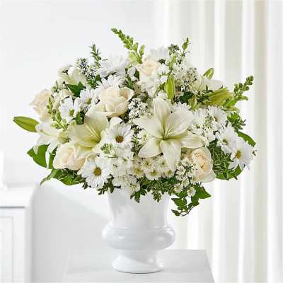 White floral arrangement in a white pedestal vase