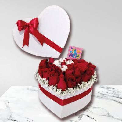 Heart-shaped box of red roses with chocolates and a red ribbon