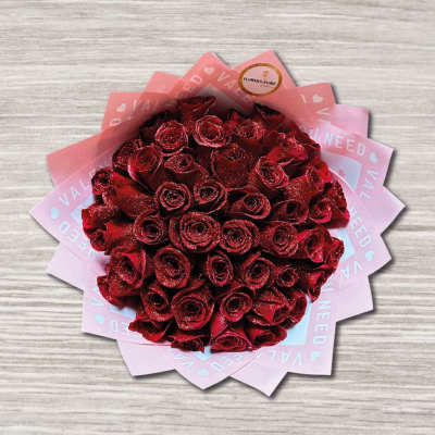 Bouquet of red roses wrapped in pink paper