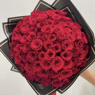 Large bouquet of red roses wrapped in black paper