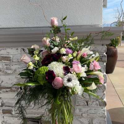 Tall mixed bouquet in a clear glass vase with pink, white, and purple blooms
