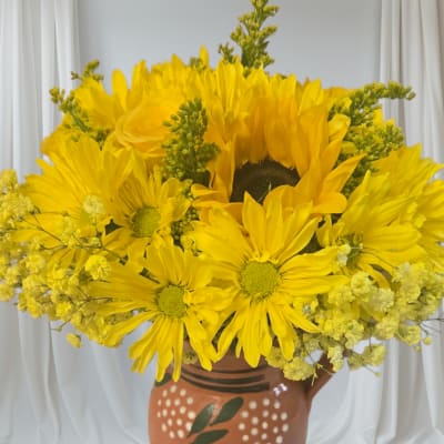 Yellow daisy bouquet in a painted terracotta vase