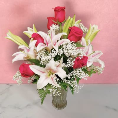 Bouquet of pink roses and white lilies in a clear glass vase