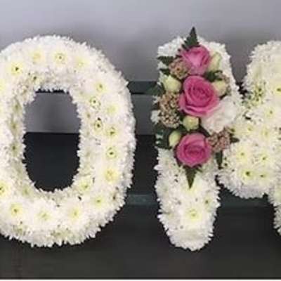 Floral letters spelling MOM in white and pink flowers