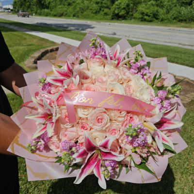 Large bouquet of pale pink roses and pink lilies wrapped in pink paper