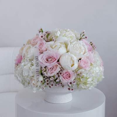 Round bouquet of pink and white flowers in a white vase