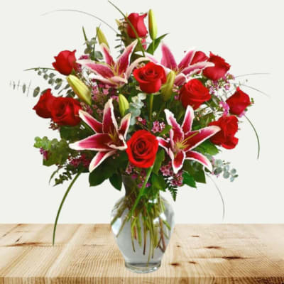 Red roses and pink lilies in a clear glass vase