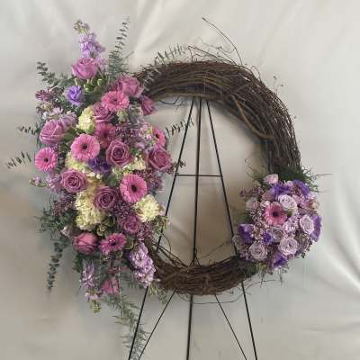 Floral wreath with pink and purple flowers on a twig ring stand