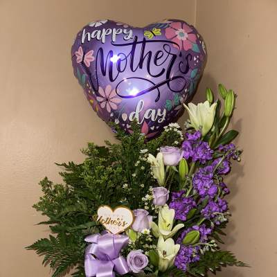 Purple Mother's Day balloon above a lavender floral arrangement in a box