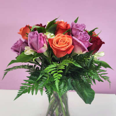 Bouquet of multicolored roses in a clear glass vase