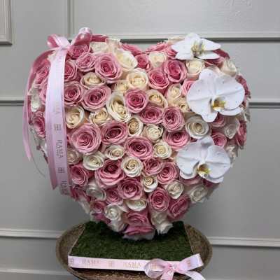 Heart-shaped arrangement of pink and white roses with white orchids