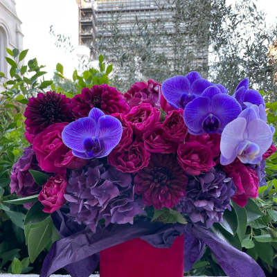 Bouquet of purple and magenta flowers in a red box