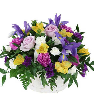 Mixed bouquet of roses, lilies, and carnations in a white basket