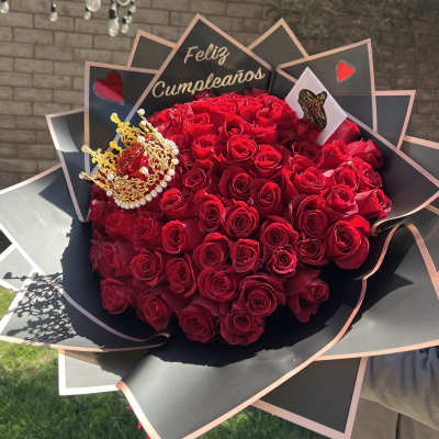 Large bouquet of red roses with a gold crown and birthday sign