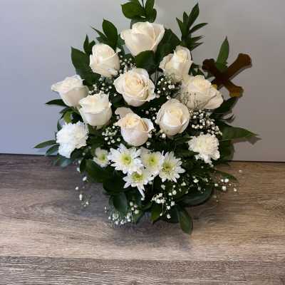 White roses and daisies arranged with baby's breath in a low bouquet