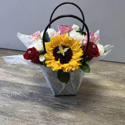 Sunflower and rose arrangement in a handled gift bag