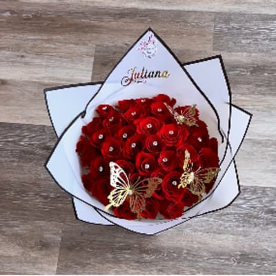 Bouquet of red roses wrapped in white paper with butterfly accents
