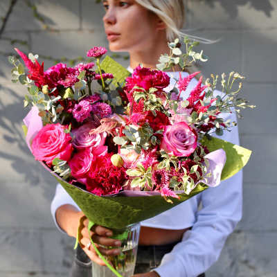 Large bouquet of pink and magenta flowers in a glass vase