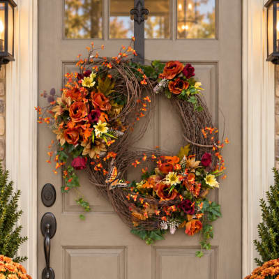 Autumn wreath with orange and burgundy flowers on a front door