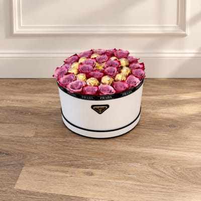 Pink roses and gold chocolates arranged in a white round box