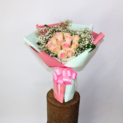 Bouquet of pink roses with baby's breath wrapped in pastel paper