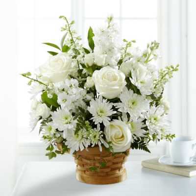 White roses and daisies arranged in a woven basket