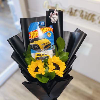 Sunflower bouquet with a Hot Wheels toy car package in black wrap