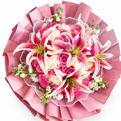 Pink and white bouquet with lilies and roses wrapped in pink paper