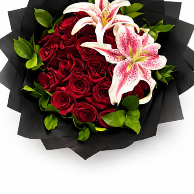 Bouquet of red roses and pink lilies wrapped in black paper
