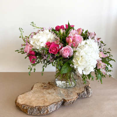 Pink and white flower arrangement in a clear glass vase