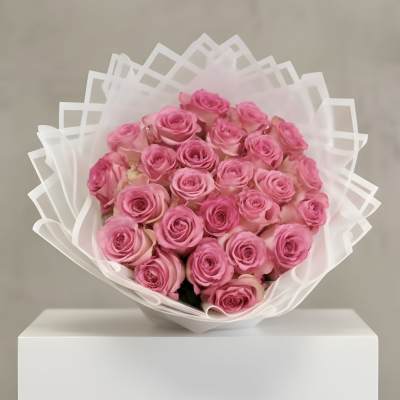 Large bouquet of pink roses wrapped in layered white translucent paper