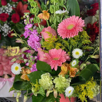 Mixed bouquet with pink gerberas, lilies, and purple blooms in a vase