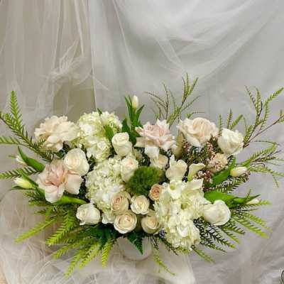 Cream and blush floral arrangement in a white vase
