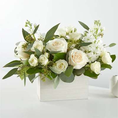 White roses and white blooms arranged in a white rectangular box