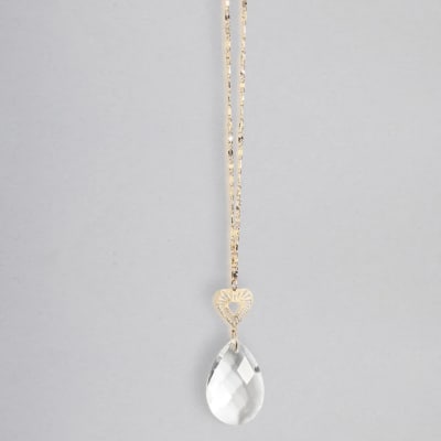 Gold chain necklace with a small heart charm and a clear teardrop crystal pendant