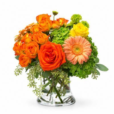 Orange and yellow roses with a peach gerbera daisy in a glass vase