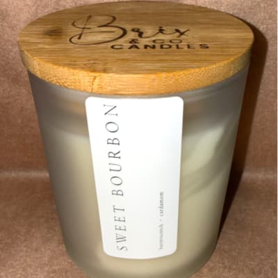 Frosted glass candle jar with a bamboo lid and label
