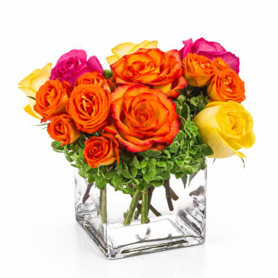 Orange, pink, and yellow roses in a clear square vase