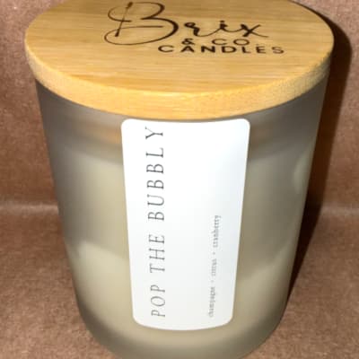 Pop The Bubbly candle in a frosted glass jar with a bamboo lid