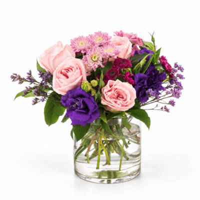 Pink and purple mixed bouquet in a clear glass vase