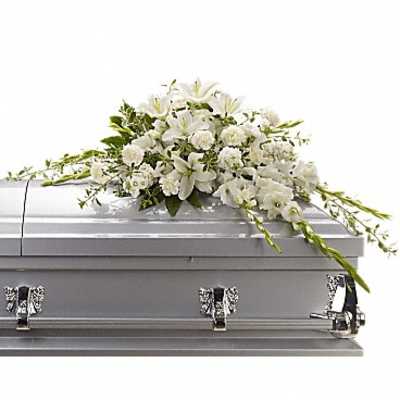 White floral casket spray on a silver casket