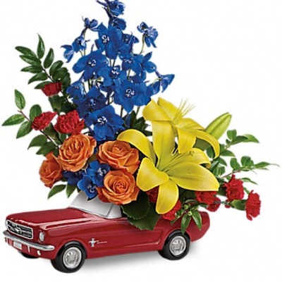 Bouquet of mixed flowers arranged in a red toy car