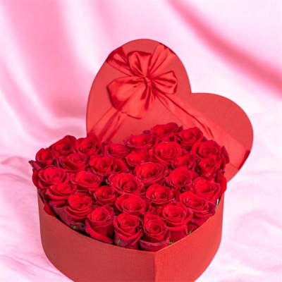 Heart-shaped box filled with red roses and a red bow