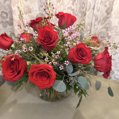 Bouquet of red roses with pink filler flowers in a glass vase