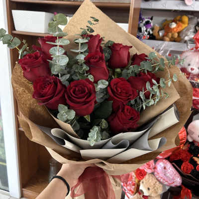 Bouquet of red roses with eucalyptus in brown paper wrap